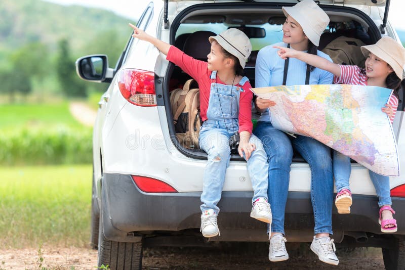 Kinderen die van de groeps reizen de Aziatische familie kaart controleren en op het het autoavontuur en toerisme voor bestemming stock afbeeldingen Kinderen die van de groeps reizen de Aziatische familie kaart controleren en op het het autoavontuur en toerisme voor bestemming stock afbeeldingen