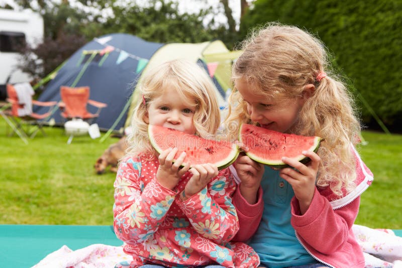 Kinderen die van Picknick genieten terwijl op Familie Kampeervakantie stock foto's Kinderen die van Picknick genieten terwijl op Familie Kampeervakantie stock foto's