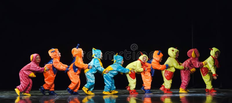 Kinderen in grappige gekleurde overallvreemdelingen die op stadium dansen stock afbeeldingen Kinderen in grappige gekleurde overallvreemdelingen die op stadium dansen stock afbeeldingen