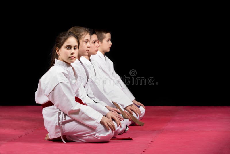 Children in kimono sitting on tatami on martial arts seminar. Selective focus. Children in kimono sitting on tatami on martial arts seminar. Selective focus.