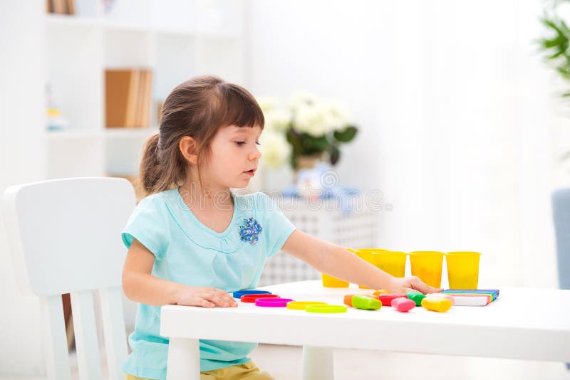 Kinderencreativiteit Het jonge geitje beeldhouwt van klei Leuke meisjevormen van plasticine op lijst in ruimte royalty-vrije stock afbeelding Kinderencreativiteit Het jonge geitje beeldhouwt van klei Leuke meisjevormen van plasticine op lijst in ruimte royalty-vrije stock afbeelding
