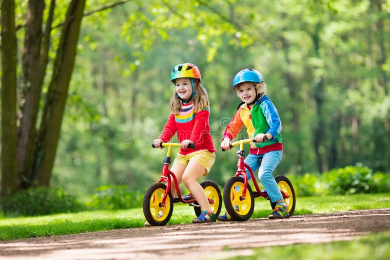 Kinderfahrbalancenfahrrad im Park lizenzfreies stockfoto Kinderfahrbalancenfahrrad im Park lizenzfreies stockfoto