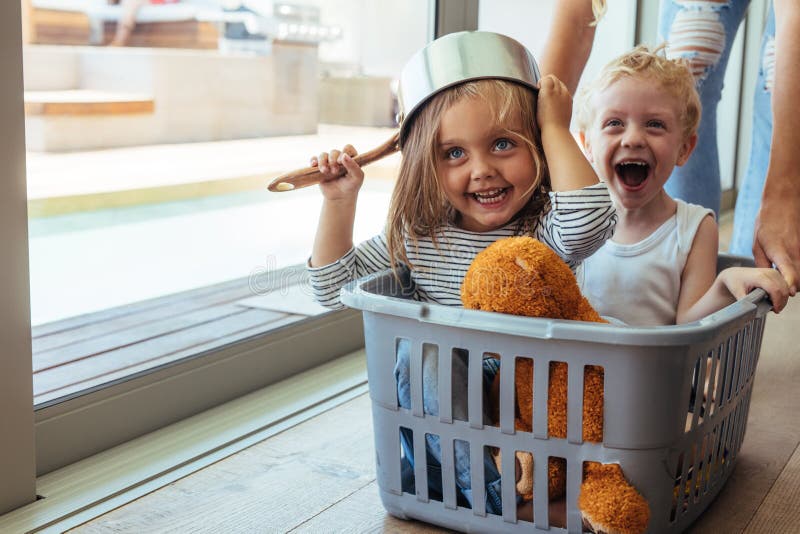 Kinderfahrten in einem Wäschekorb lizenzfreie stockbilder Kinderfahrten in einem Wäschekorb lizenzfreie stockbilder