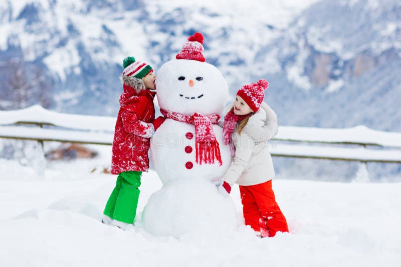 Kindergebäudeschneemann Kinder errichten Schneemann stockbilder Kindergebäudeschneemann Kinder errichten Schneemann stockbilder