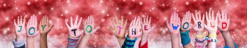 Kinderhände, die den Wortfreude Weltroten Weihnachtshintergrund aufbauen