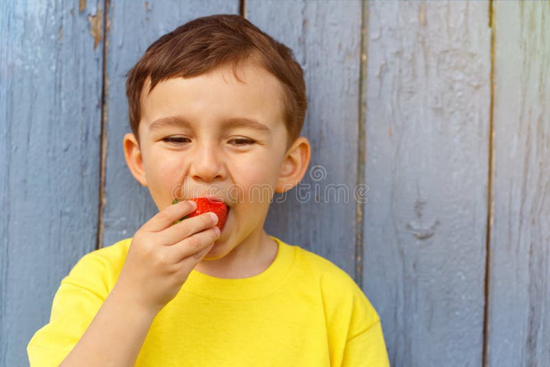 Kinderkinderkleiner Junge, der Erdbeerfrucht-Sommererdbeeren isst lizenzfreies stockbild Kinderkinderkleiner Junge, der Erdbeerfrucht-Sommererdbeeren isst lizenzfreies stockbild
