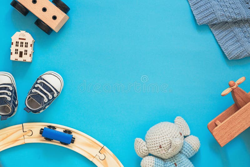Kinderlayout auf blauem Hintergrund niedliche Holzspielzeug und Kleinkinder erste Schuhe Platz für Text frei stockfoto