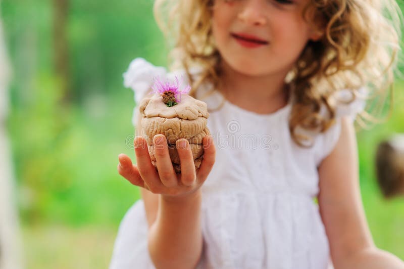 Kindermädchen, das mit dem Salzteigkuchen verziert mit Blume spielt lizenzfreies stockbild
