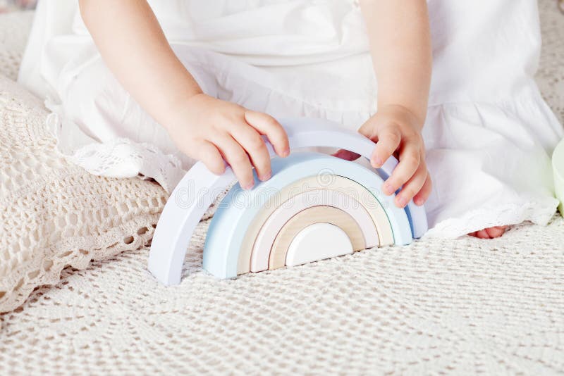 Kindermädchen, die mit einer hölzernen Spielzeugpyramide spielen Kleines süßes Mädchen mit Naturspielzeug Nahaufnahme stockfoto Kindermädchen, die mit einer hölzernen Spielzeugpyramide spielen Kleines süßes Mädchen mit Naturspielzeug Nahaufnahme stockfoto