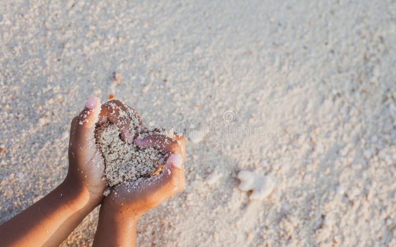 Kindermädchen-Holdingsand Herzform in den Händen und das Spielen auf dem Strand machen