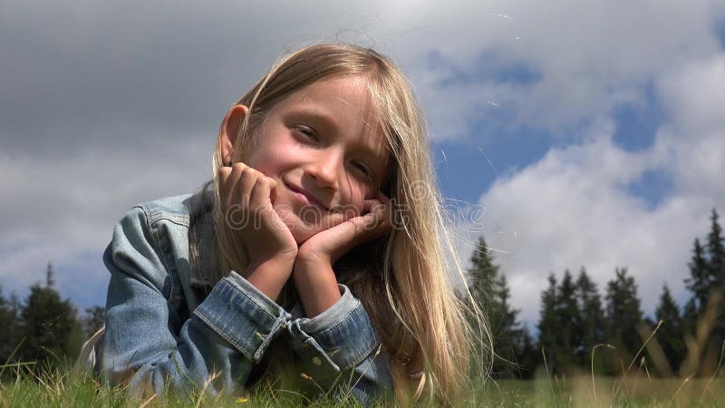 Kinderportret glimlachend kind dat speelt in een parkblij meisje dat achter gesloten deuren kijkt