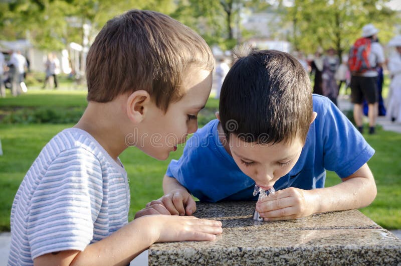 Kindertrinkwasser vom Brunnen stockbild Kindertrinkwasser vom Brunnen stockbild