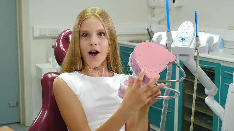 Kinderzahnheilkunde Zahnschutzkonzept Hübsches 10-jähriges Mädchen mit Zahnmodell in Händen Lächelnder fröhlicher Patient stock video