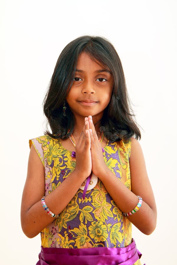 Asian Indian girl greeting in a tradtional Indian welcome, namaste, with a smile. Asian Indian girl greeting in a tradtional Indian welcome, namaste, with a smile