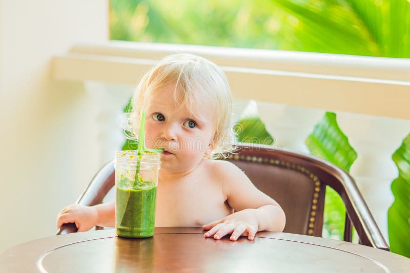 Kindjongen die gezonde groene plantaardige smoothie drinken - het gezonde eten, veganist, vegetariër, natuurvoeding en drankconce stock foto Kindjongen die gezonde groene plantaardige smoothie drinken - het gezonde eten, veganist, vegetariër, natuurvoeding en drankconce stock foto