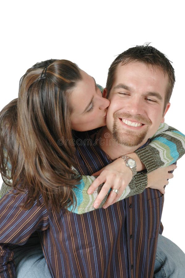 Wife gives her man a kiss on the cheek while he carries her on his back. Wife gives her man a kiss on the cheek while he carries her on his back.