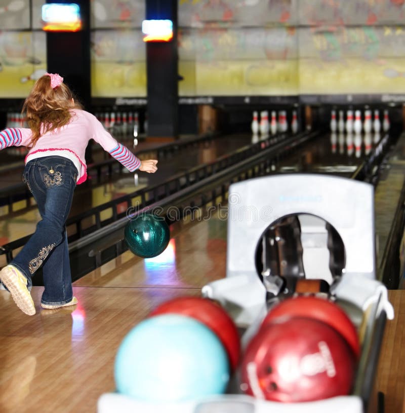 Kindmädchen innen mit Bowlingspielkugel. stockfoto Kindmädchen innen mit Bowlingspielkugel. stockfoto