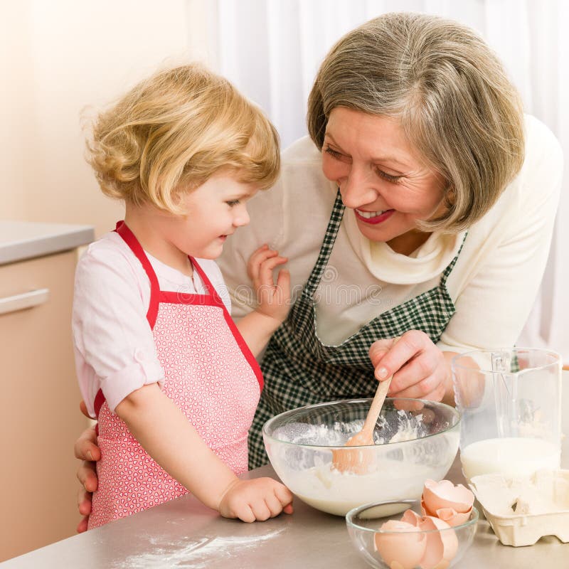 Kindmädchen- und -großmutterbackenkuchen lizenzfreie stockfotografie Kindmädchen- und -großmutterbackenkuchen lizenzfreie stockfotografie