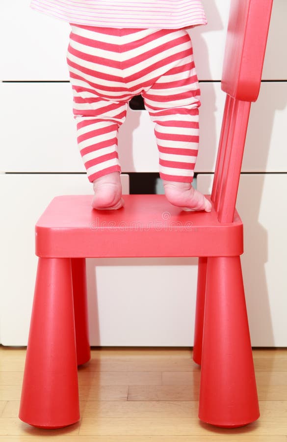 Child feet on baby chair, concept of danger, risk and parent responsibility. Child feet on baby chair, concept of danger, risk and parent responsibility