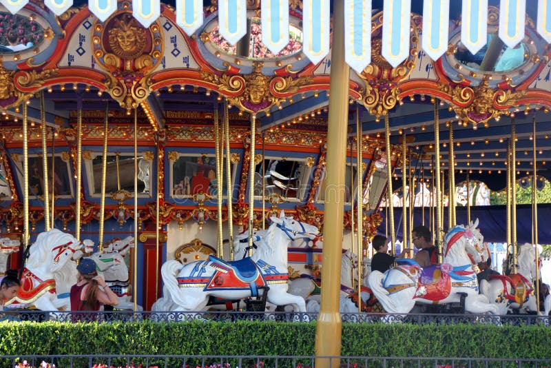 King Arthur Carrousel, Disneyland, Anaheim, California, with white painted galloping horses, each having its own name, with music in the background