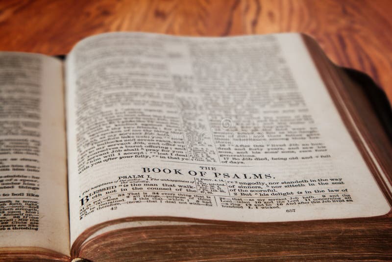 Closeup of an old Holy Bible opened to the famous Book of Psalm on a rustic wooden table. Deliberate focus on the title with shallow depth of field on background. This translation is King James, which is public domain. Closeup of an old Holy Bible opened to the famous Book of Psalm on a rustic wooden table. Deliberate focus on the title with shallow depth of field on background. This translation is King James, which is public domain.