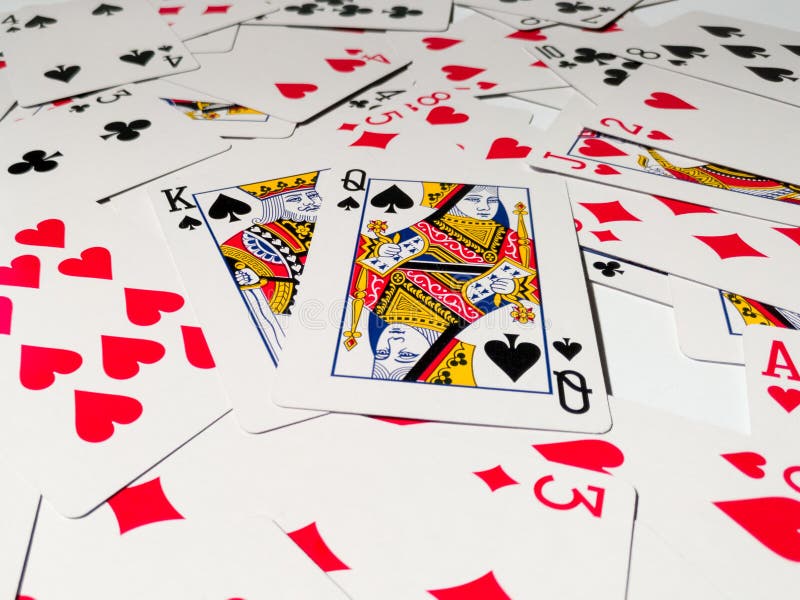 A King and Queen Card with a Spade Suit from a Deck of Playing Cards on a Pile of Scattered