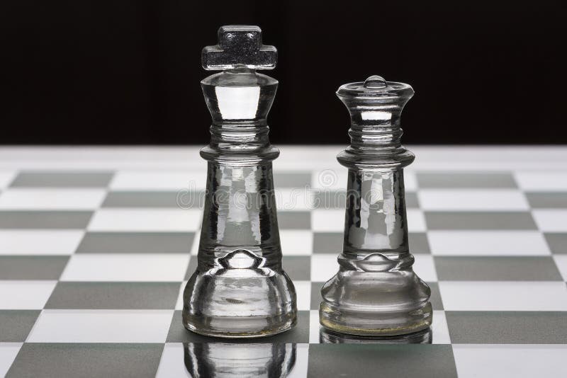 King and queen glass chess piece facing each other in black and white