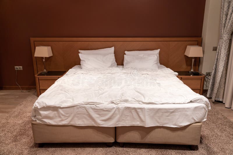 King Size Bed in Hotel Room with Bedside Tables and Lamps Stock Image