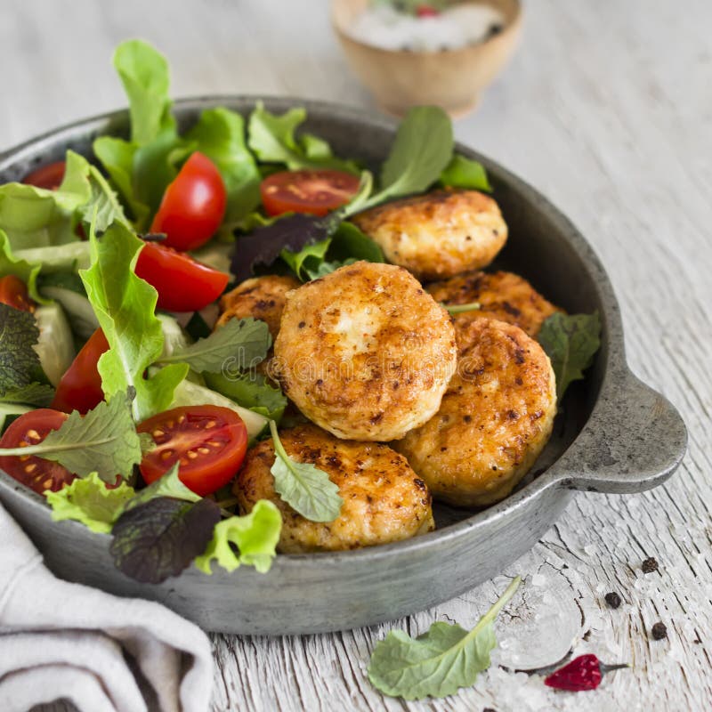 Kippenkoteletten en verse groentesalade in een uitstekende pan royalty-vrije stock afbeeldingen Kippenkoteletten en verse groentesalade in een uitstekende pan royalty-vrije stock afbeeldingen