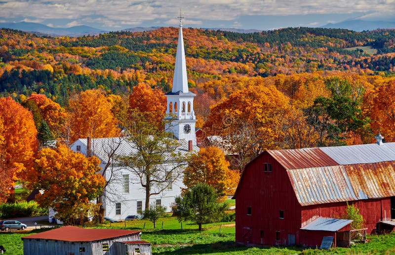 Kirche und Bauernhof mit roter Scheune am Herbst