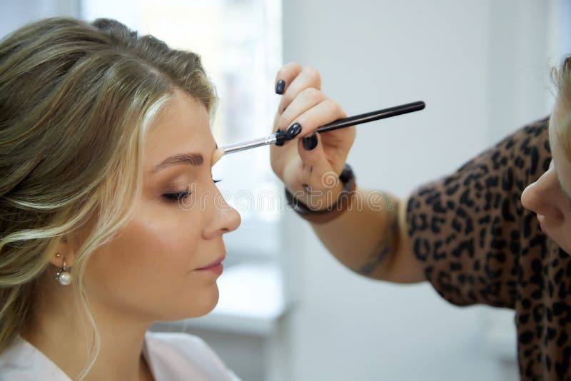 Kirov, Russia - August 28, 2020: Stylist or make up artist making makeup for beautiful bride on the wedding day