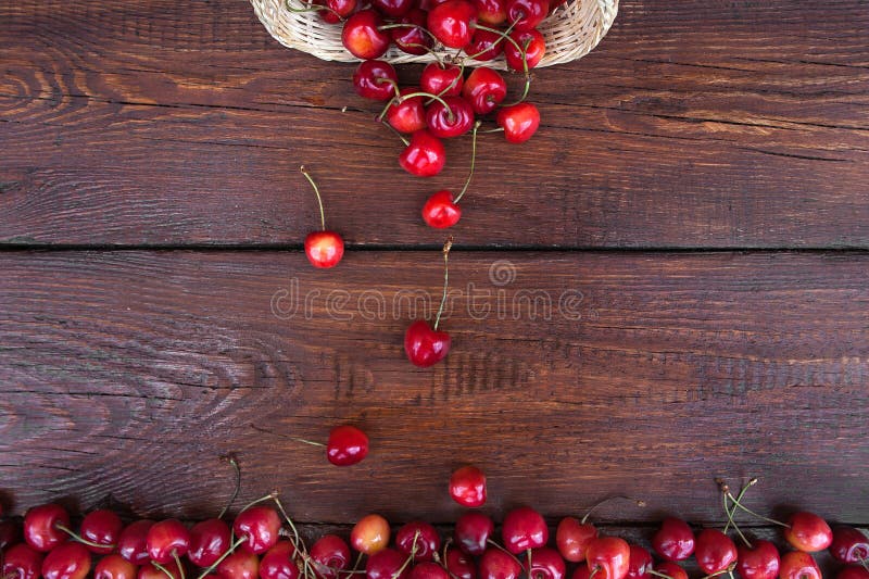 Kirschbeere in einen großen Stapel von Beeren mit einem Strohweidenkorb lizenzfreies stockbild Kirschbeere in einen großen Stapel von Beeren mit einem Strohweidenkorb lizenzfreies stockbild