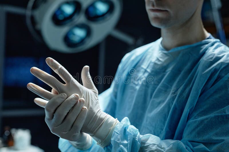 Kirurg som bär skyddshandskar i operationsrummet fotografering för bildbyråer