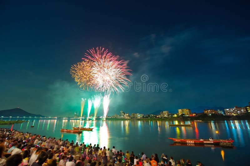 Inuyama City, Japan - August 10, 2011 : crowd people enjoy fireworks display over Kiso River. Inuyama City, Japan - August 10, 2011 : crowd people enjoy fireworks display over Kiso River.