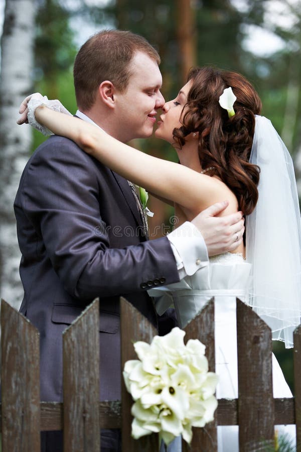 Romantic Kiss Bride And Groom Through The Foliage Stock Photo Image