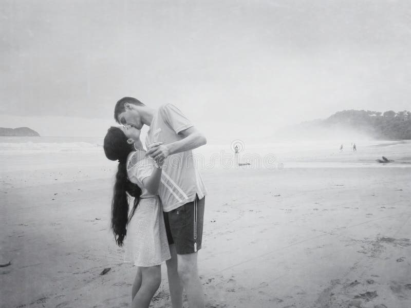 Kiss of a happy young romantic couple in love on the beach. royalty free stock photo