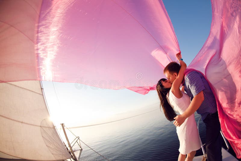 L'uomo e la ragazza baciare sotto la vela.