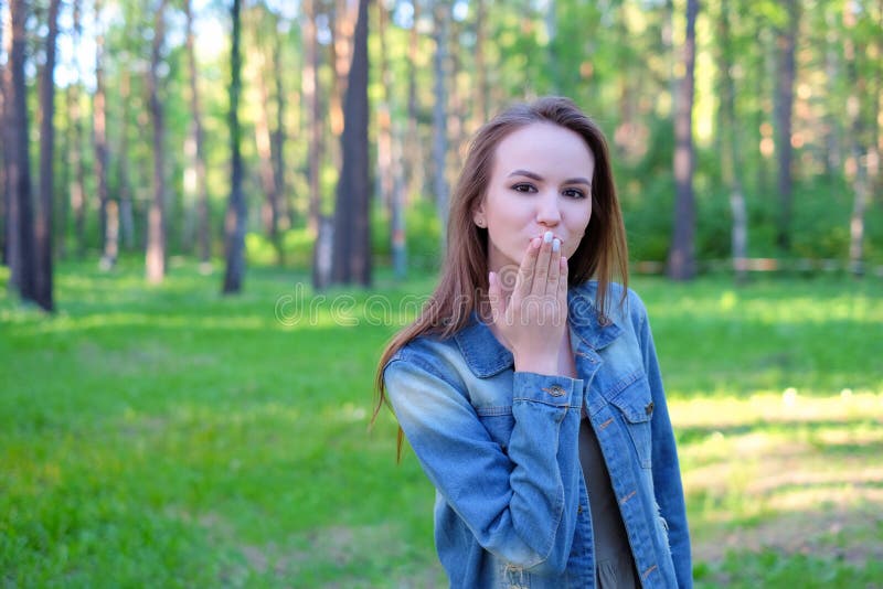 Kiss for you. Happy carefree girl on a holiday is sending an air kiss to her lover stock photo Kiss for you. Happy carefree girl on a holiday is sending an air kiss to her lover stock photo
