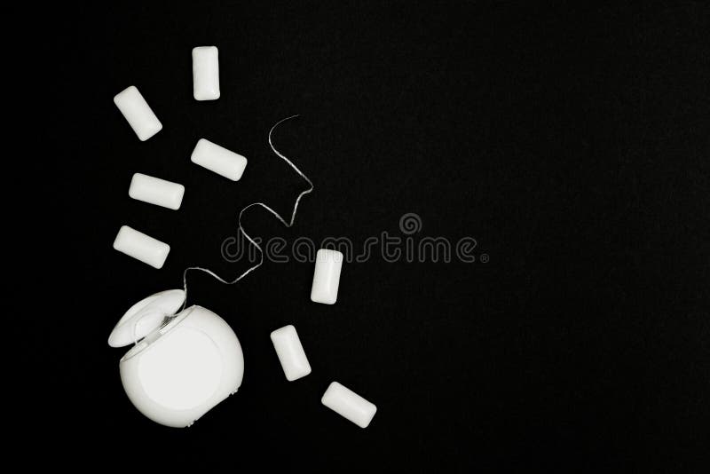 Kissen der Zahnseide und des Kaugummis auf einem schwarzen Hintergrund stockfotografie Kissen der Zahnseide und des Kaugummis auf einem schwarzen Hintergrund stockfotografie