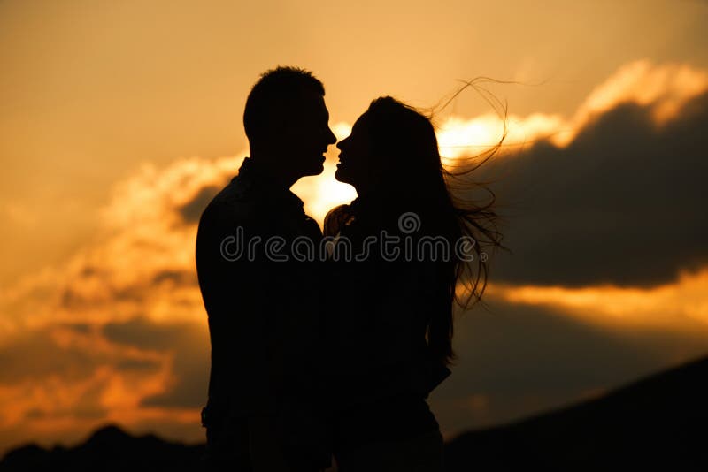 Kissing couple silhouette in the sunset sky