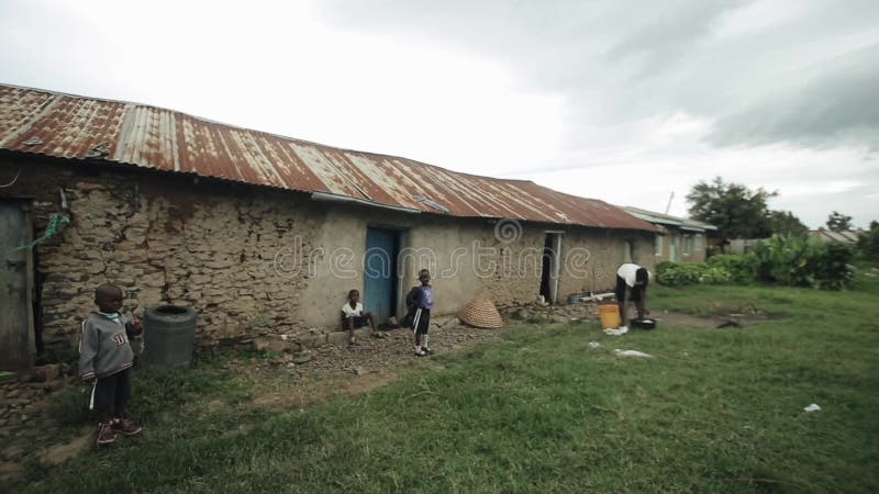 KISUMU KENJA, MAJ, - 15, 2018: Afrykańska rodzina, dzieci i matka, stoimy blisko ich domu w biednej wiosce w Afryka