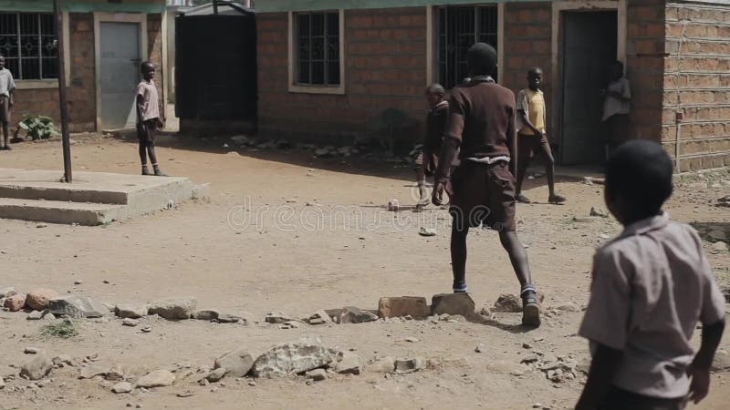 KISUMU KENJA, MAJ, - 15, 2018: Grupa afrykańscy dzieci w mundurze bawić się futbol na zewnątrz szkoły wpólnie, cieszy się