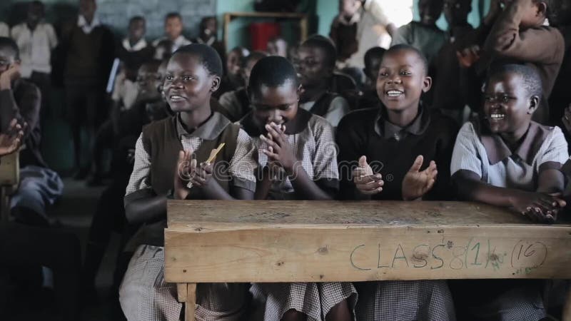 KISUMU KENJA, MAJ, - 21, 2018: Grupa szczęśliwi Afrykańscy dzieci siedzi w sala lekcyjnej i ono uśmiecha się, śmia się wpólnie