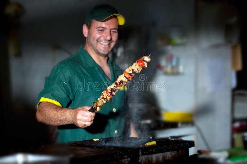 Vedúci podržte špízy obalené v kuchyni.