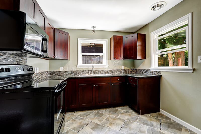 Kitchen with bright burgundy cabinets and black appliances