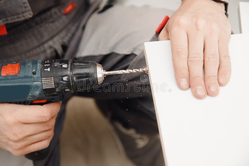 Kitchen Installation, Worker Tightens Bolts To Assemble Box from