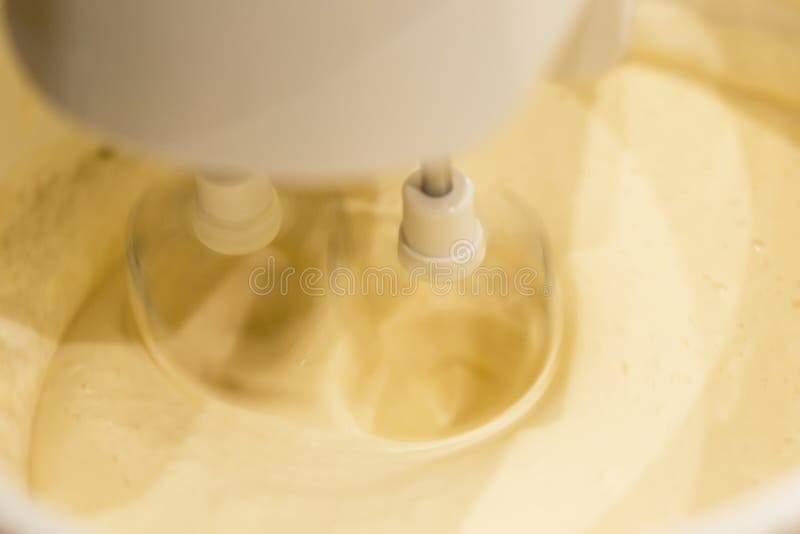 A Kitchen Mixer with Yellow Egg Yolks Mixed with Sugar in a Modern