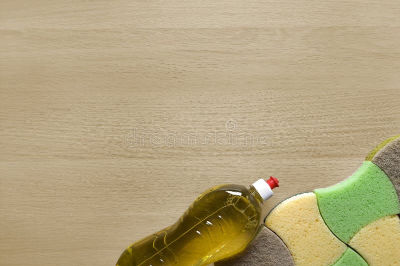 Kitchen sponges and bottle of detergent on table. Template for advertising, articles with kitchen cleaning sponges and washing liquid on wooden background. Flat