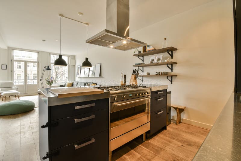 a modern kitchen with black cabinets and stainless steel range hoods on the wall above it is an open fireplace. a modern kitchen with black cabinets and stainless steel range hoods on the wall above it is an open fireplace