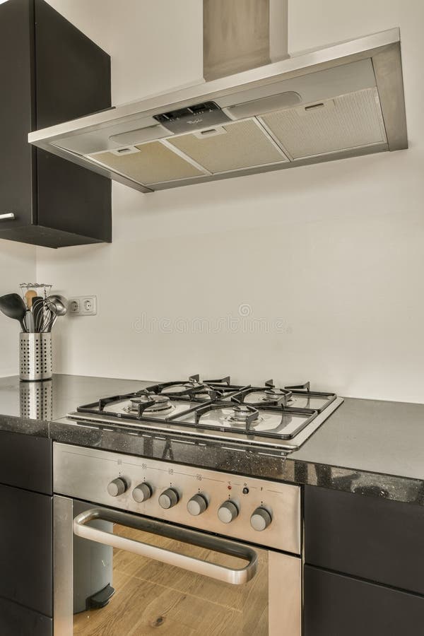a modern kitchen with black cabinets and stainless steel range hoods on the stove in this image is taken from above. a modern kitchen with black cabinets and stainless steel range hoods on the stove in this image is taken from above